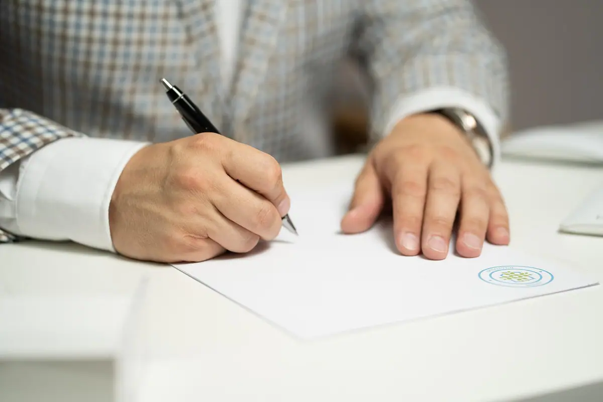 Contrato, bolígrafo y cámara preparados sobre una mesa