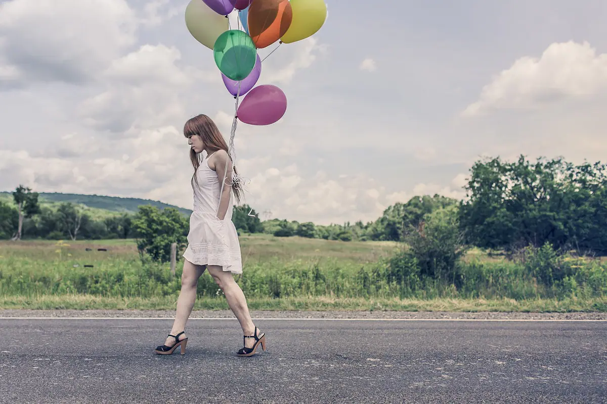Mujer posando con globos durante una sesión de cumpleaños