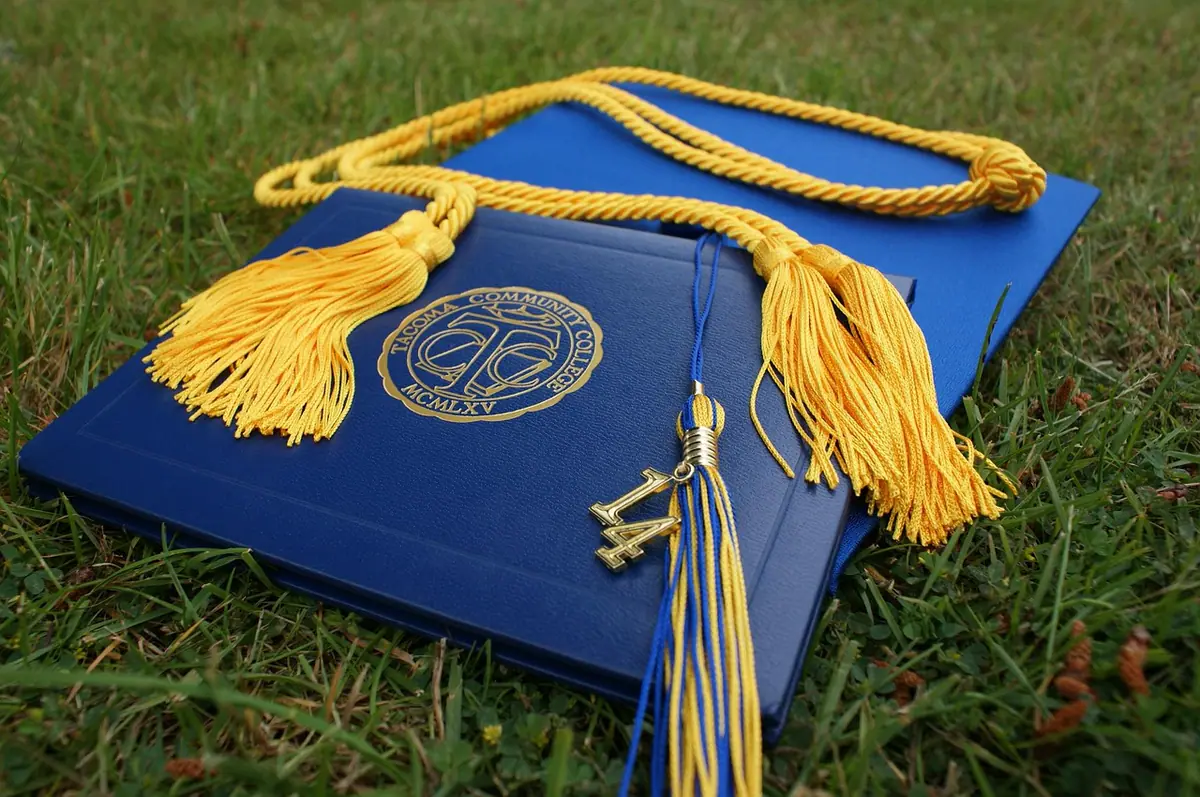 Birrete y estola de graduación colocados sobre un diploma
