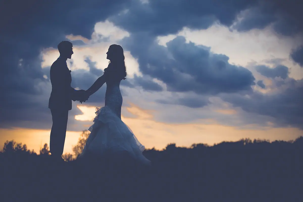 Pareja en silueta frente al cielo al atardecer