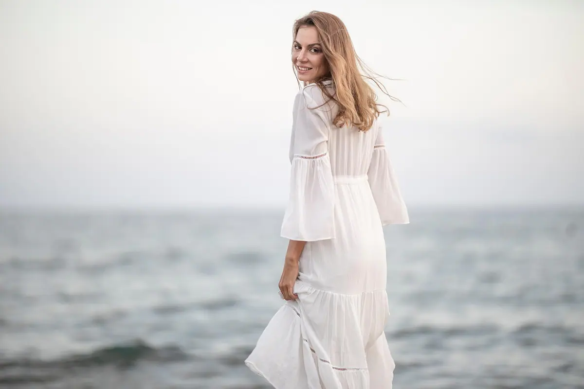Mujer posando en la playa con el mar al fondo