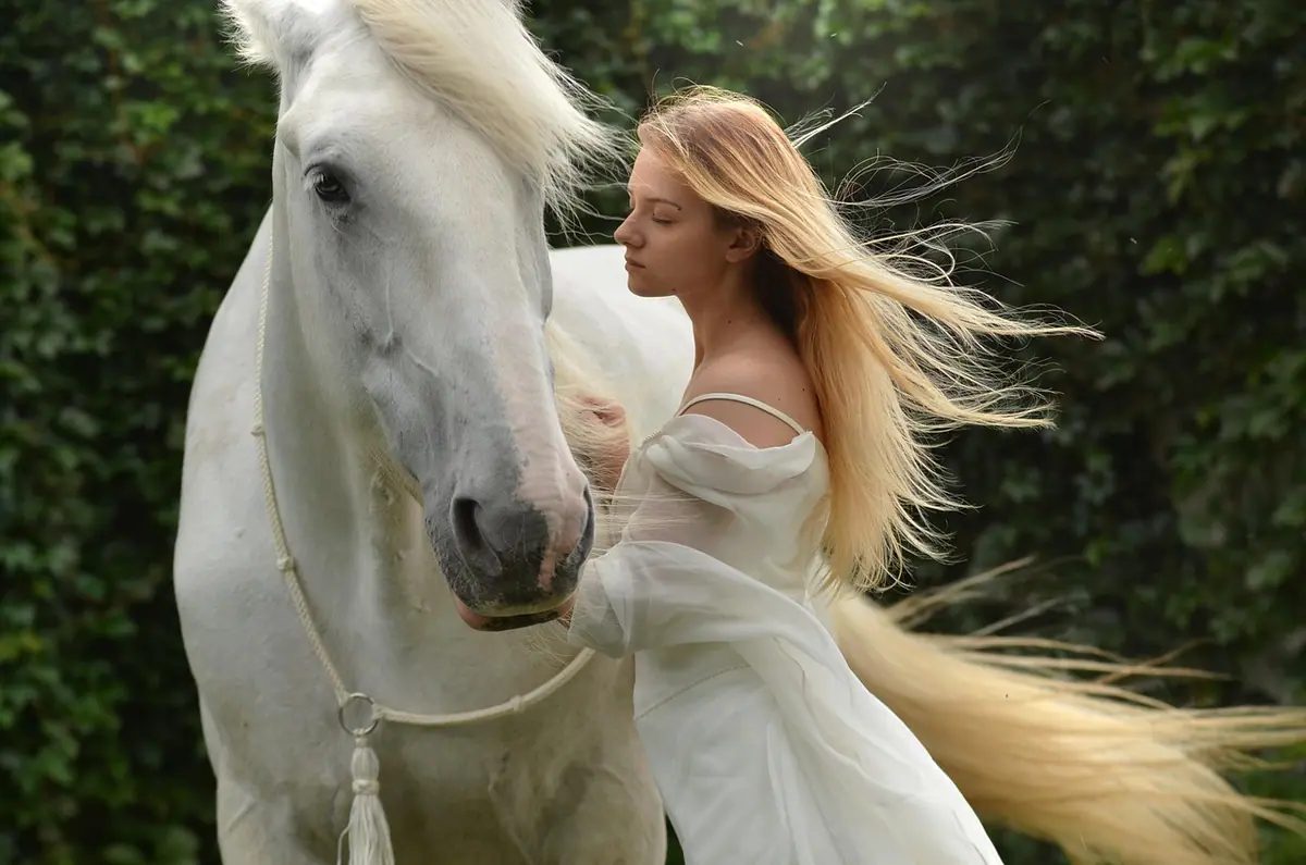Mujer posando junto a un caballo durante una sesión al aire libre