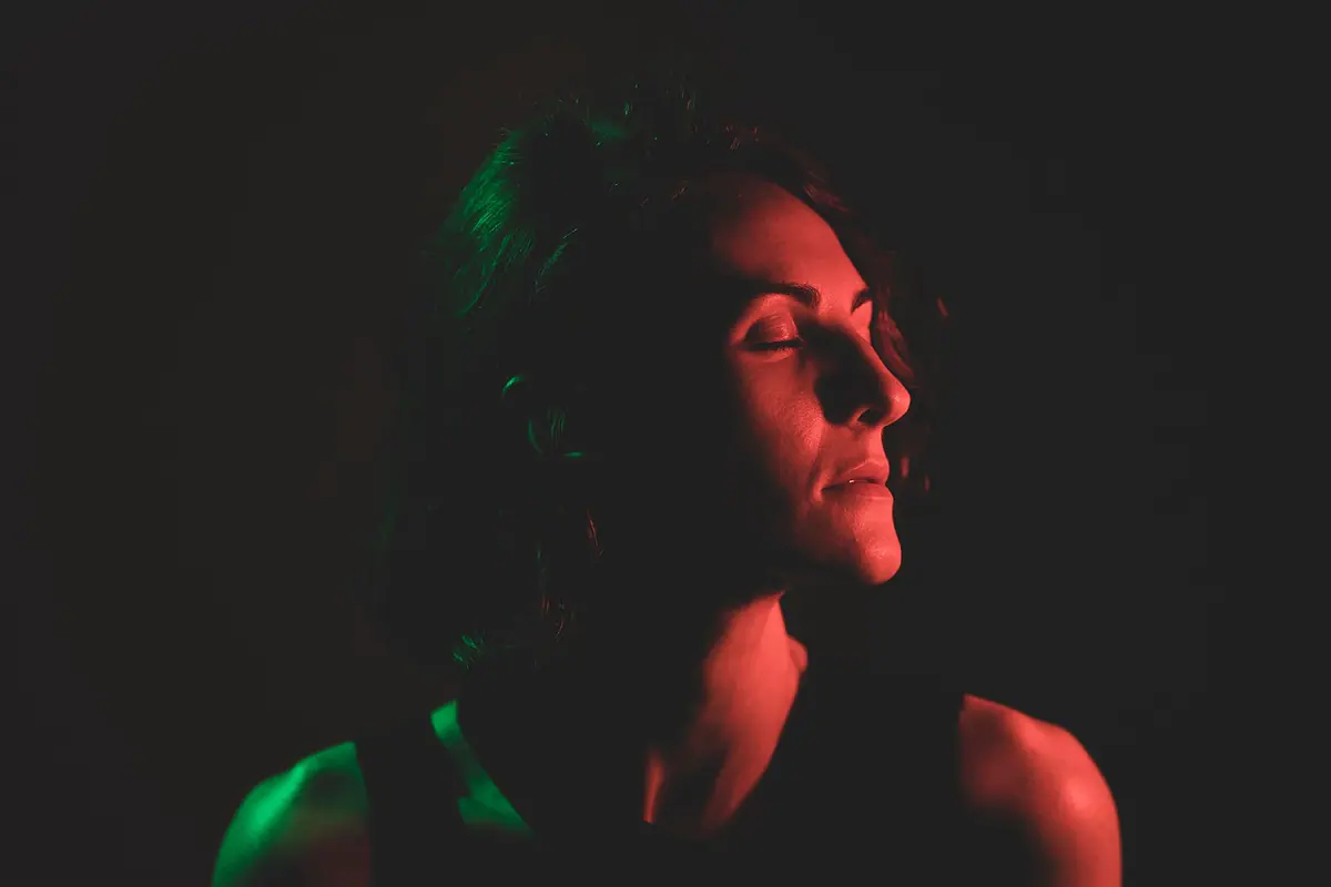 Rostro de una mujer iluminado lateralmente en estudio