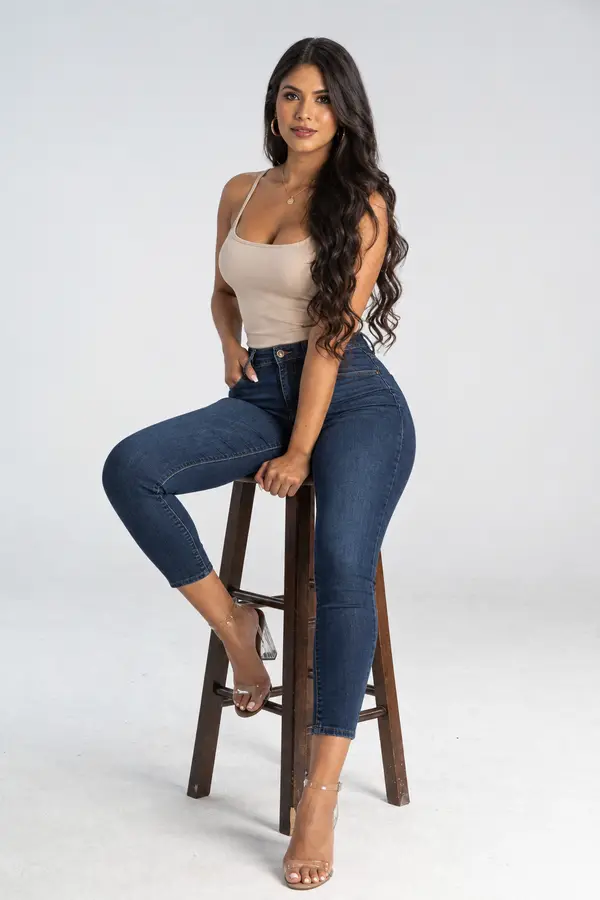 Mujer sentada en un banco alto, cuerpo completo, en estudio
